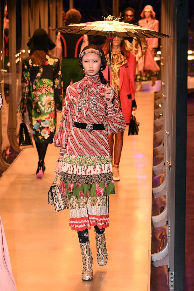 A female model walking with two Gucci bags