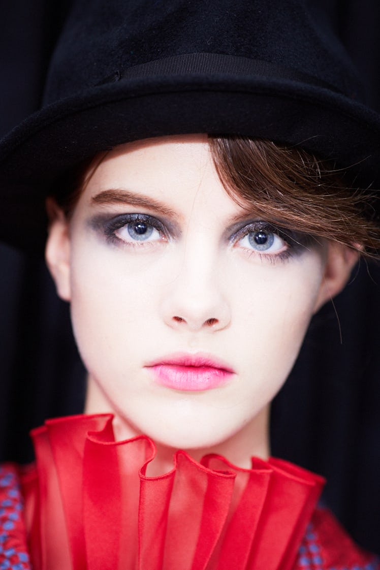 Closeup of a female model posing with a black model hat