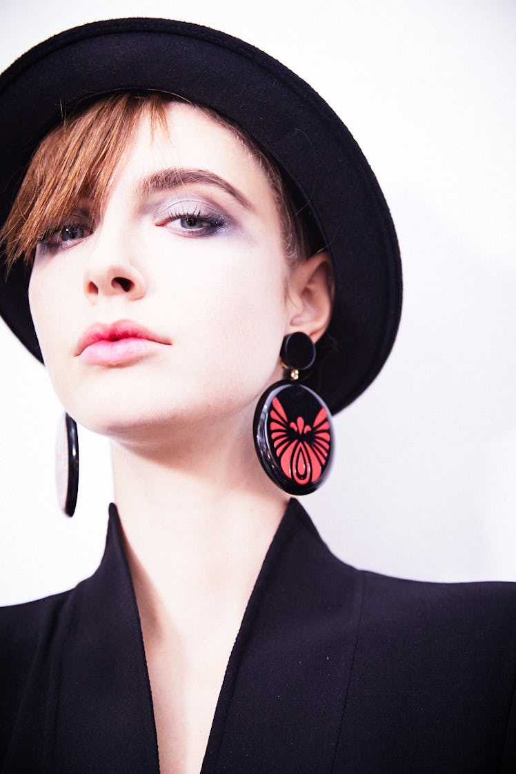 Closeup of a female model that is wearing a black hat and black blazer