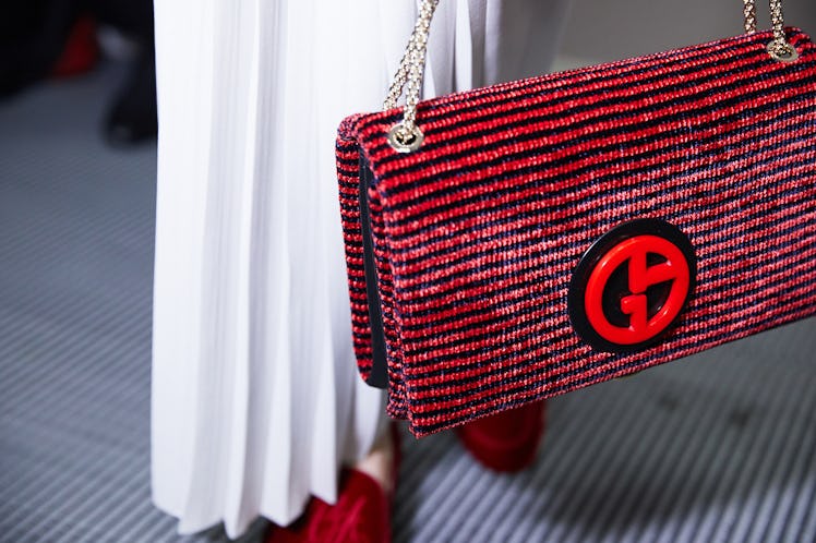 A woman holding a red handbag