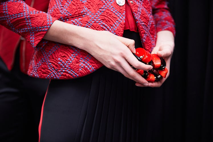 A woman wearing a red blazer and black pants