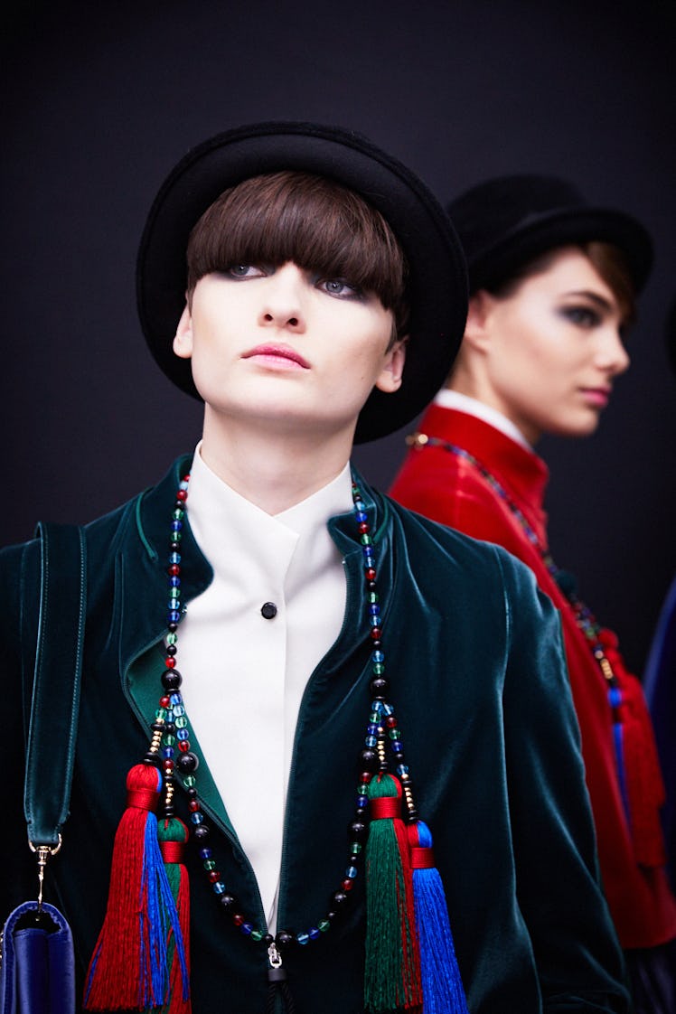 Two women wearing blue and red coats and black hats