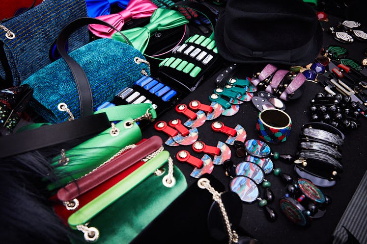 A lot of handbags and colorful accessories on a black table 