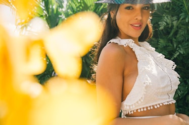 Eiza Gonzalez in a white crop top and a black straw hat at Veuve Clicquot’s Third Annual Carnaval pa...
