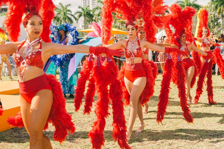 Dancers in red outfits and matching feather hats at Veuve Clicquot’s Third Annual Carnaval party in ...