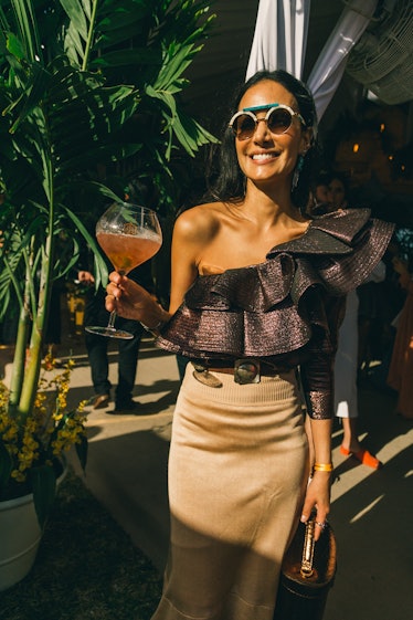 Attendee in a one-shoulder frilled top and a beige skirt at Veuve Clicquot’s Third Annual Carnaval p...