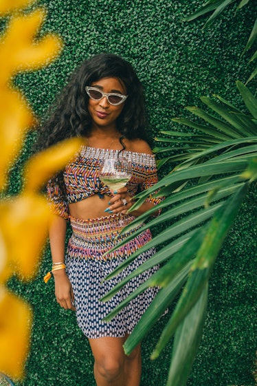 A woman wearing a tribal-print two-piece holding her drink at Veuve Clicquot’s Third Annual Carnaval...