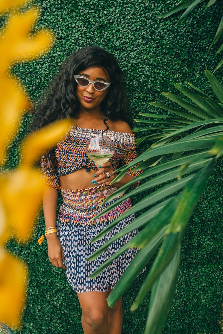 A woman wearing a tribal-print two-piece holding her drink at Veuve Clicquot’s Third Annual Carnaval...