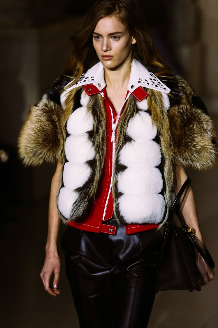 A model walking the runway in Louis Vuitton’s fur vest and black leather pants during Fall 2017 fash...
