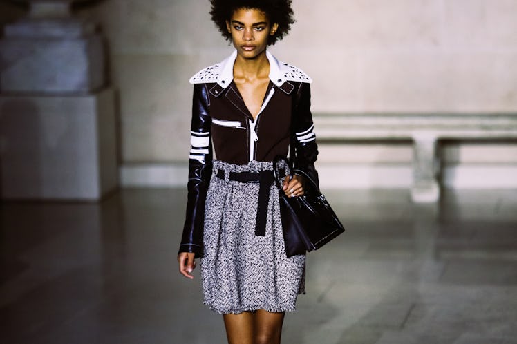 A model walking the runway in a dress and a black-and-white cropped leather jacket from Louis Vuitto...