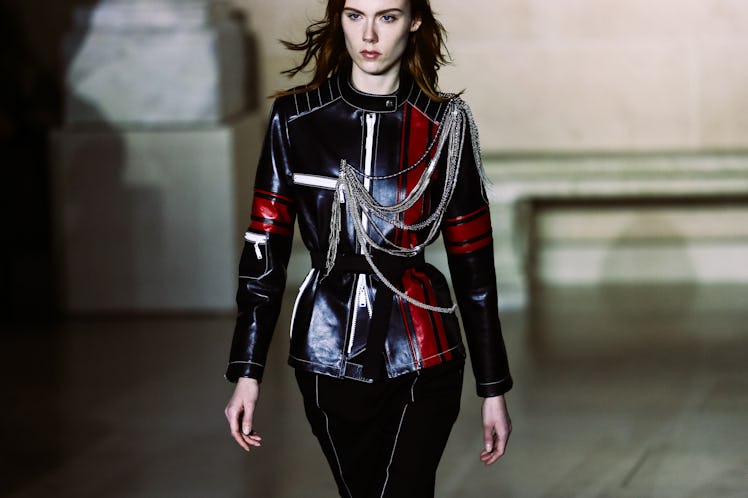 A model in Louis Vuitton’s black pants and a black leather jacket with red and white details, adorne...