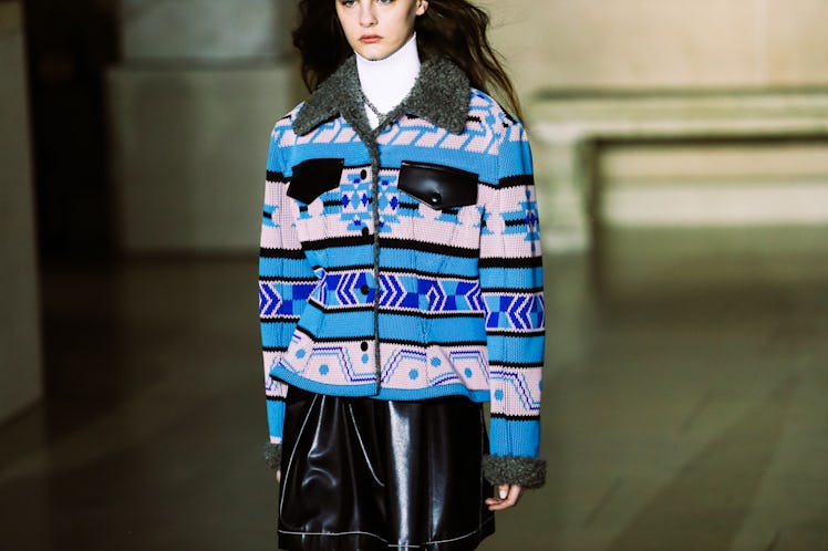 A model wearing a jacket in blue hues and a black leather skirt from Louis Vuitton’s Fall 2017 Colle...