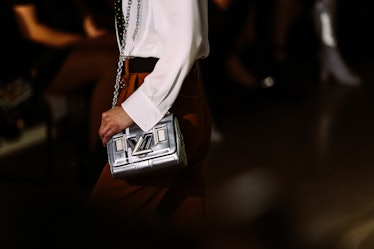 A model walking the runway for Louis Vuitton’s Fall 2017 show with a silver handbag.