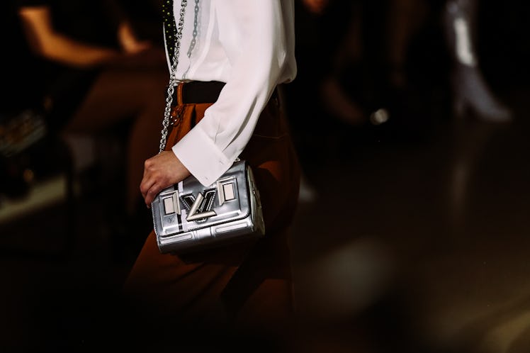 A model walking the runway for Louis Vuitton’s Fall 2017 show with a silver handbag.