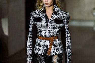 A model in Louis Vuitton’s Fall 2017 plaid jacket walking the runway.