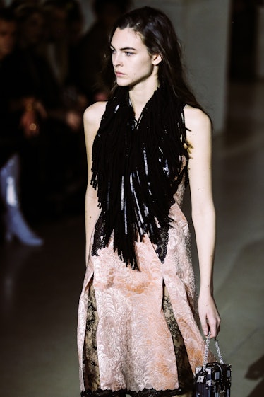 A model in a pink velvet dress with a black frilled neckline walking the runway for Louis Vuitton’s ...