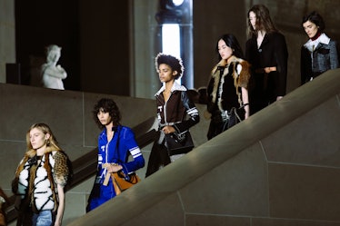 Models wearing looks from Louis Vuitton’s Fall 2017 collection walking down the stairs.