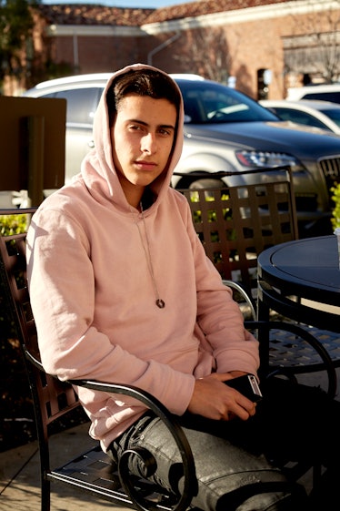 A boy wearing pink hoodie posing for a photo in Calabasas