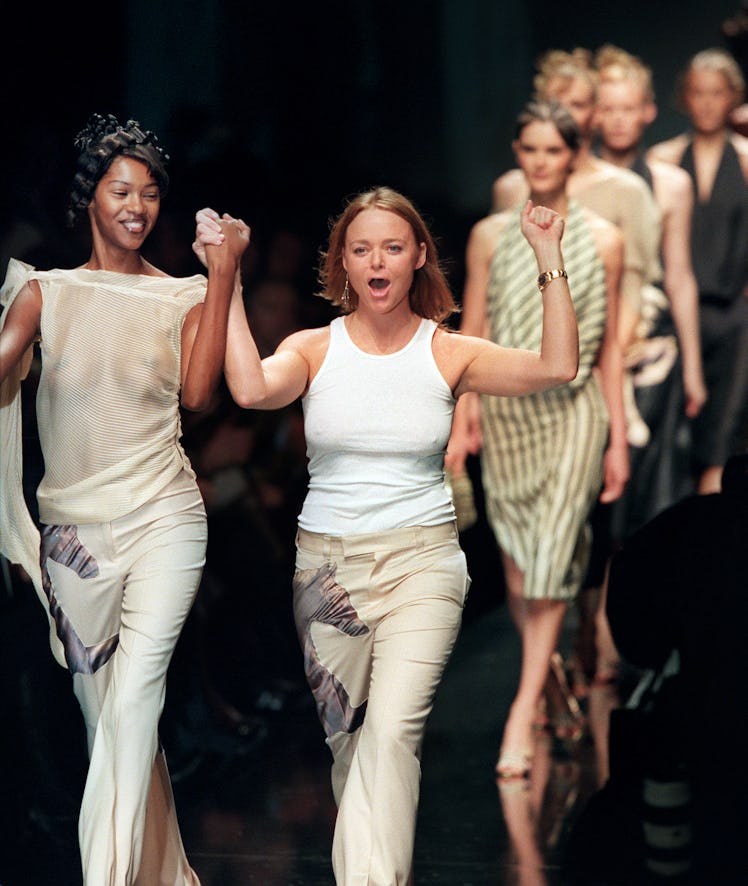Stella McCartney taking a lap around the runway arm in arm with Naomi Campbell while wearing matchin...
