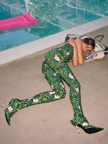 A woman lying in green leggings next to a pool on St. Patrick’s Day