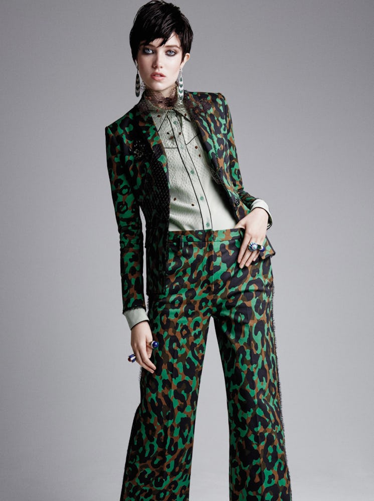 A female model posing in a green snake print blazer and pants on St. Patrick’s Day