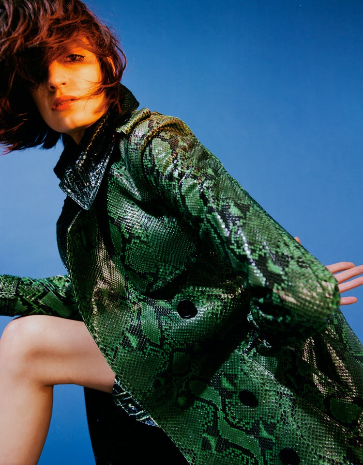 A female model posing in a green snake print dress on St. Patrick’s Day