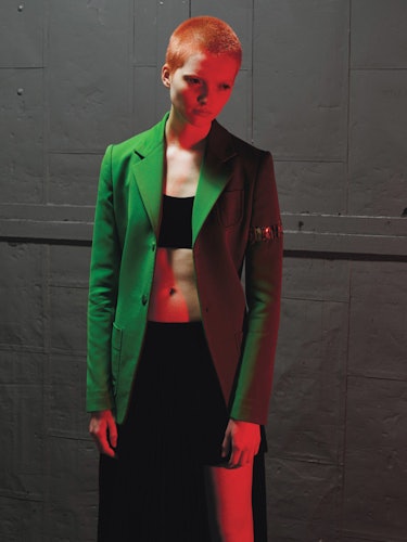 A short-haired female model posing in a green blazer on St. Patrick’s Day