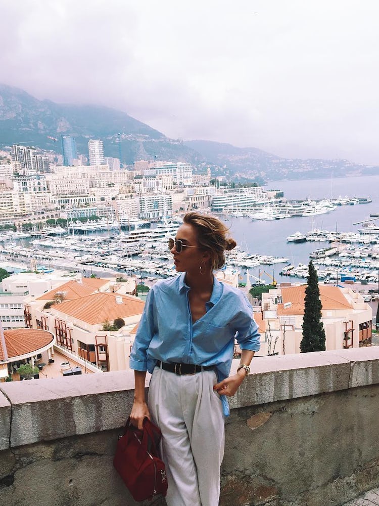 Fashion blogger Agnija Grigule posing on the walking path overlooking the Monte Carlo harbor
