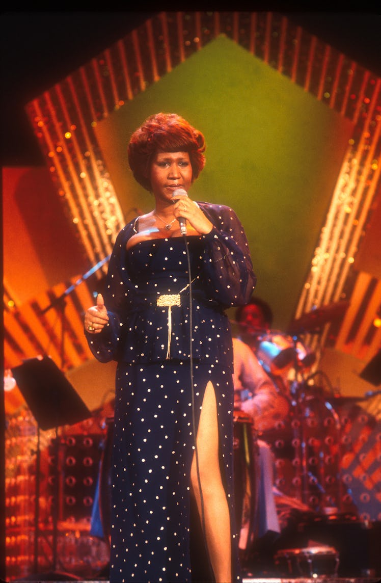 Aretha Franklin performing in a navy blue and gold dress in 1972