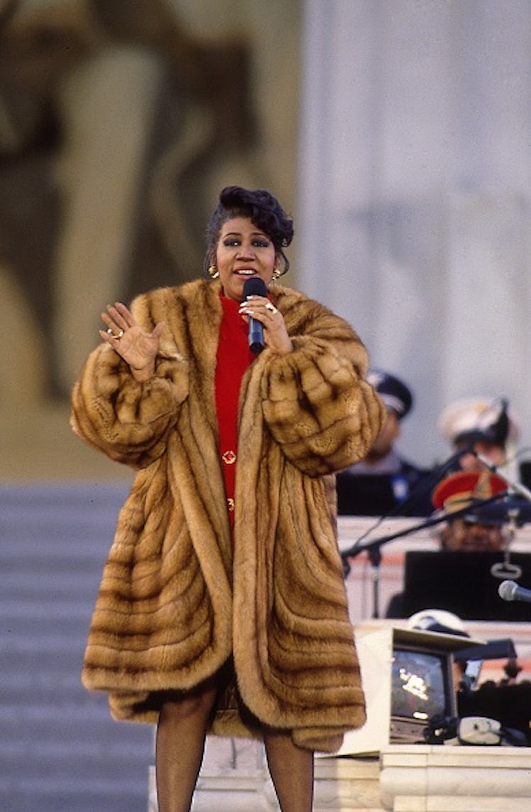 Aretha Franklin in a red dress and large brown fur coat in 1993