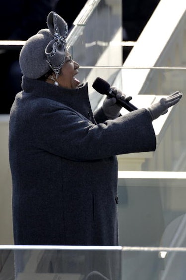 Aretha Franklin in a navy coat and grey hat performing in 2009