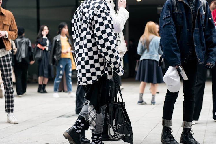 A person wearing a black-and-white checked jacket on the street during Seoul Fashion Week