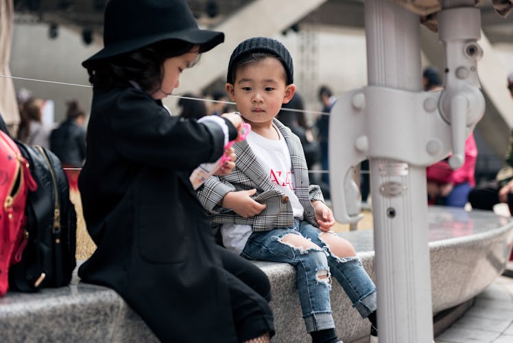 Toddlers wearing street style outfits playing during Seoul Fashion Week
