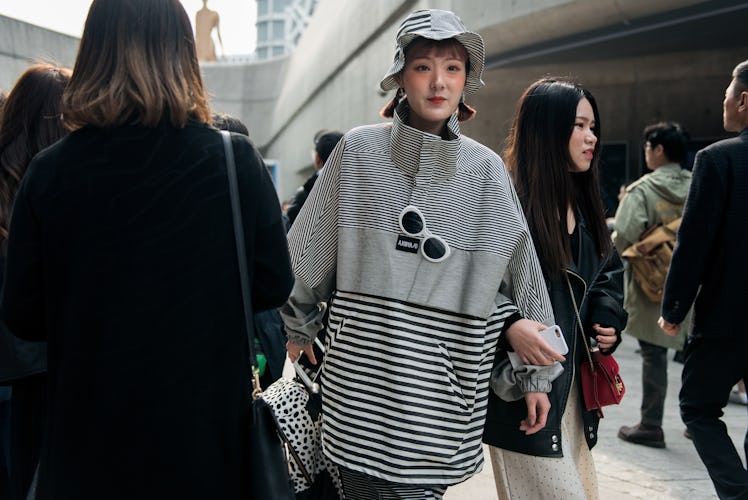 A girl wearing a stripy hoodie and a matching hat during Seoul Fashion Week.