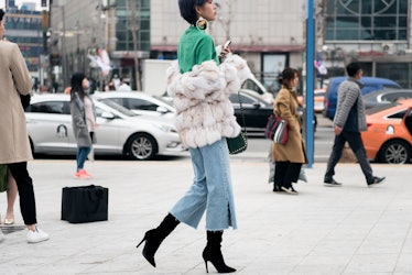 A fashionista confidently striding in her street style during Seoul Fashion Week.