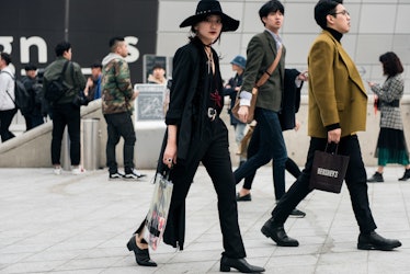 A girl wearing an all-black outfit walking the streets of Seoul.