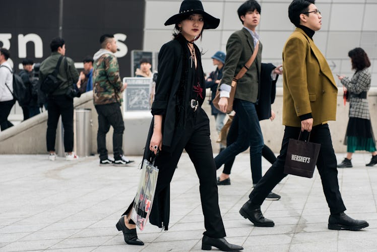 A girl wearing an all-black outfit walking the streets of Seoul.