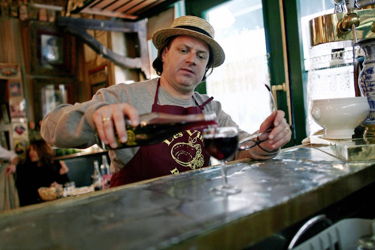 A waiter serves a glass of Beaujolais No