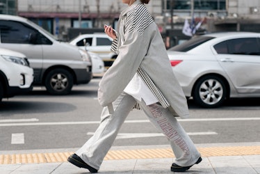 A person walking the street of Seoul in a grey tracksuit.