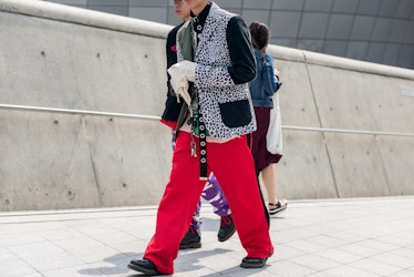 A man in red pants and a leopard-printed blazer walking the street in Seoul.