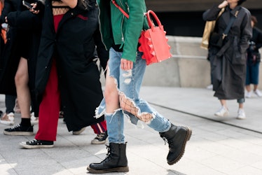 A woman walking the street of Seoul in ripped jeans and fishnets