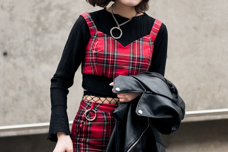 A woman wearing a tartan two-piece set with punk details