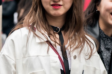 A girl in a white shirt wearing a black choker necklace