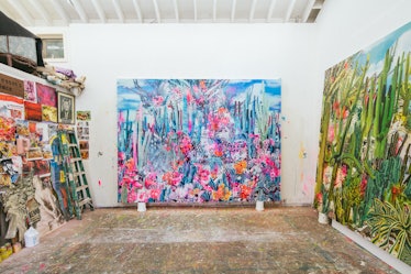 The inside of Rosson Crow studio with two multi-colored abstract paintings and painting material on ...