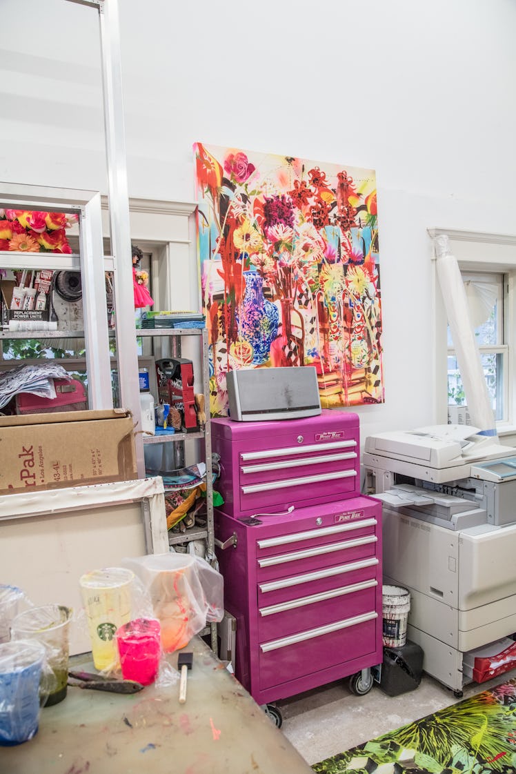 The inside of Rosson Crow studio with a copy machine, a pink drawer, paint on a table and a painting...