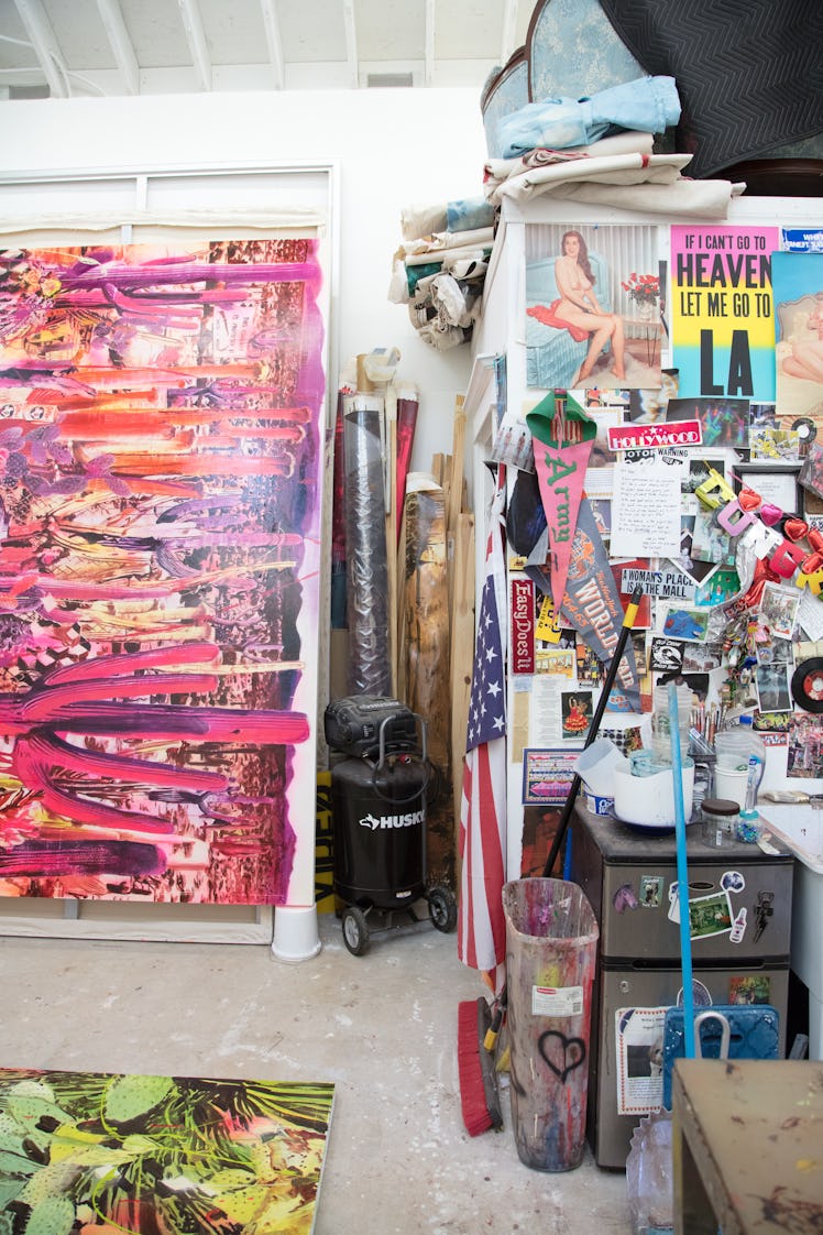 A large pink cactus painting and a wall decorated with stickers and photographs