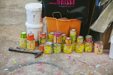 The inside of Rosson Crow studio with several yellow paint cans placed on the floor