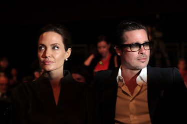 Angelina Jolie and Brad Pitt sitting at an event in London in 2014