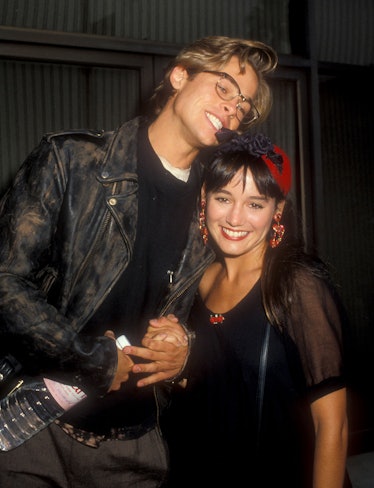 Brad Pitt holding hands with Jill Schoelen and biting on her headband