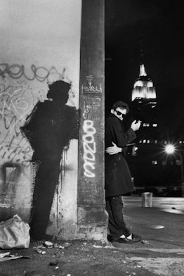 Artist Richard Hambleton outside at night with one